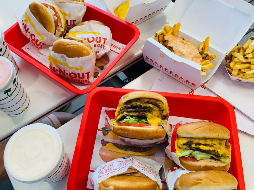 Table with two trays worth of In-N-Out burgers and fries