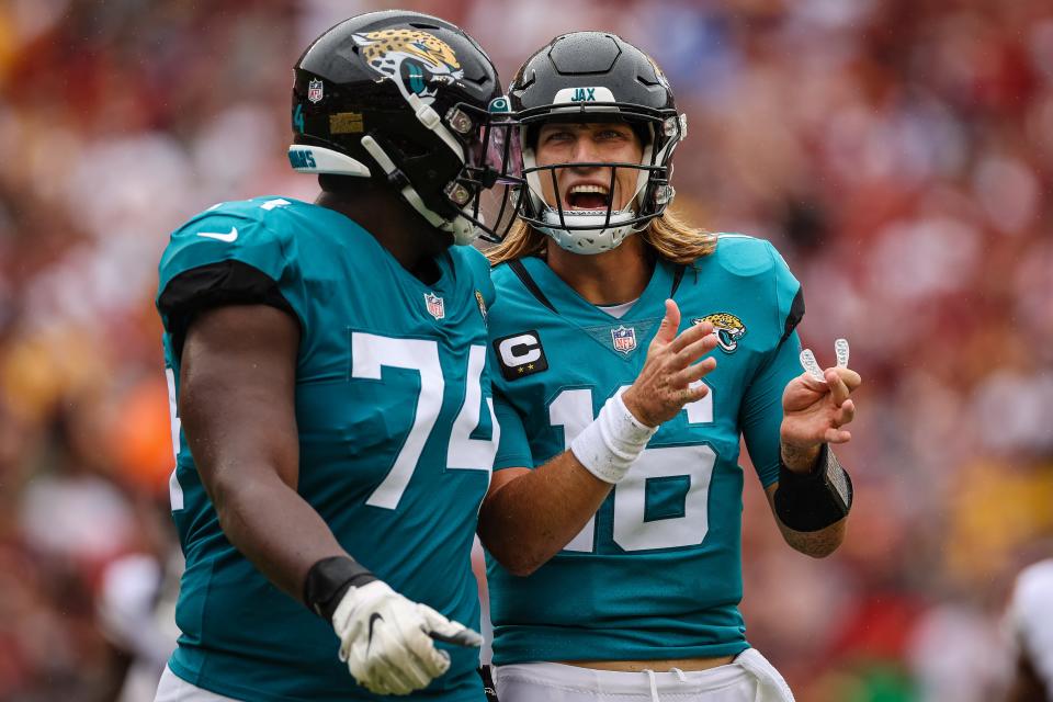 Sep 11, 2022; Landover, Maryland, USA; Jacksonville Jaguars quarterback Trevor Lawrence (16) speaks with offensive tackle Cam Robinson (74) after a play against the Washington Commanders during the first half at FedExField. Mandatory Credit: Scott Taetsch-USA TODAY Sports