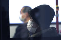 Bus passengers wear protective masks Tuesday, Feb. 25, 2020, in Tokyo. Japan's Prime Minister Shinzo Abe said Tuesday that new measures like companies letting their employees work from home and hospitals expanding their capacity to treat many patients will determine if Japan could control its coronavirus outbreak. (AP Photo/Eugene Hoshiko)