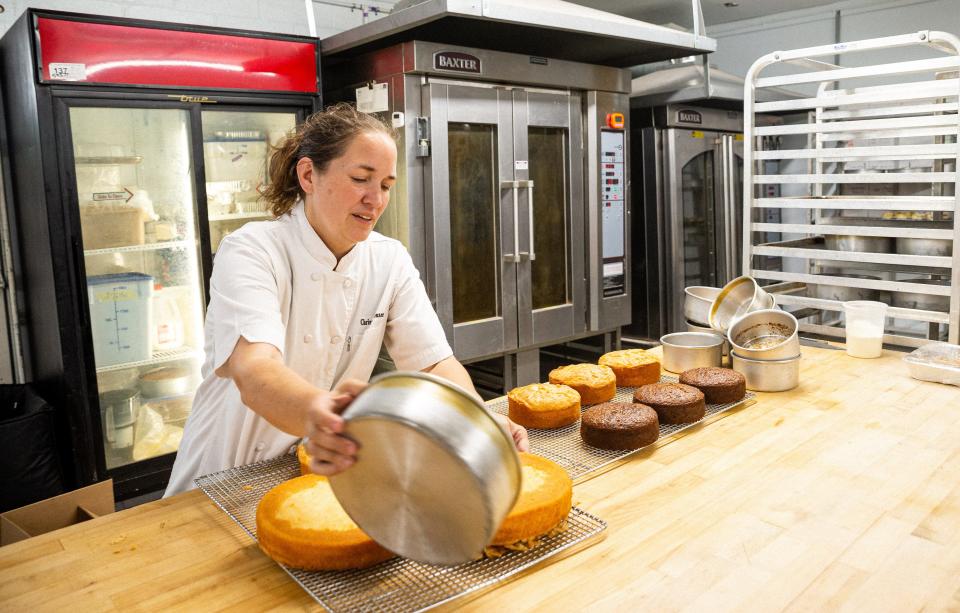 Chrissy Jensen removes cakes after they have finished baking and prepares them for the next step at The Dotted Lime Bakery in Columbia, Tenn. on Aug. 30, 2022