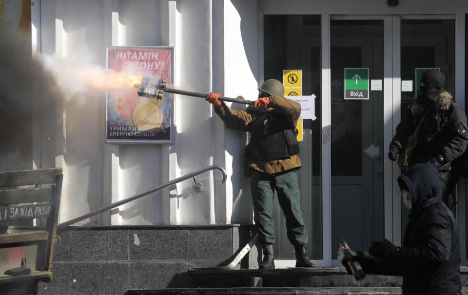 An anti-government protester fires an improvised weapon during clashes with riot police outside Ukraine's parliament in Kiev, Ukraine, Tuesday, Feb. 18, 2014. Thousands of anti-government protesters clashed with police in a new eruption of violence Tuesday. (AP Photo/Sergei Chuzavkov)