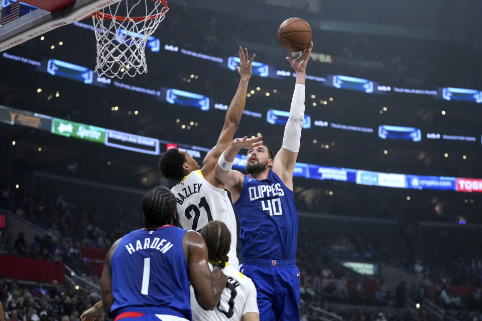 Los Angeles Clippers center Ivica Zubac (40) scores over Utah Jazz forward Darius Bazley (21) as Clippers guard James Harden (1) and Jazz guard Jason Preston watch during the first half of an NBA basketball game in Los Angeles, Friday, April 12, 2024. (AP Photo/Eric Thayer)
