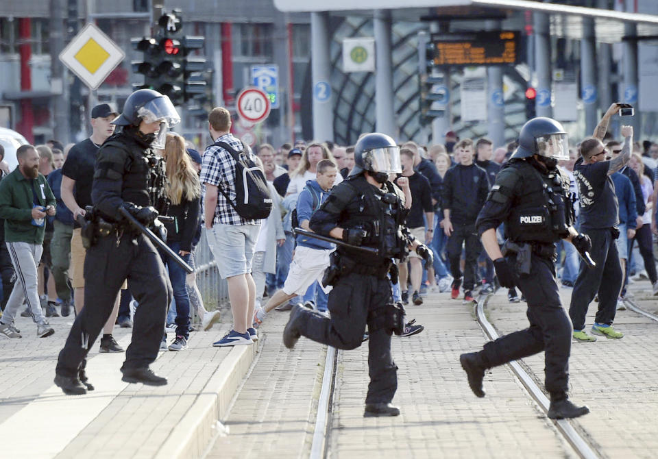 In this Aug. 27, 2018 photo police officers run during protests in Chemnitz, Germany. Authorities in the eastern German city of Chemnitz were braced for rival protests Monday amid tensions over the killing of a man in what police described as a dispute between "several people of various nationalities." The killing sparked spontaneous protests by hundreds of people late Sunday in Chemnitz, a city where almost a quarter voted for the far-right Alternative for Germany party last year. (Andreas Seidel/dpa via AP)