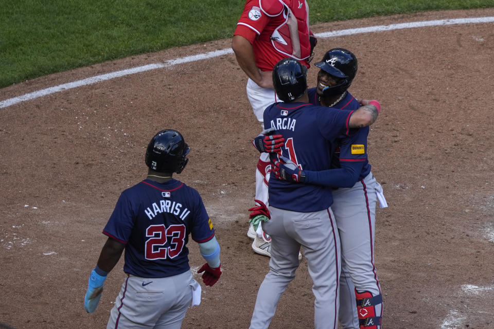 Atlanta Braves' Jorge Soler, right, embraces teammate Orlando Arcia, center, after hitting a 3-run home run during the sixth inning of a baseball game against the Cincinnati Reds, Thursday, Sept. 19, 2024, in Cincinnati. (AP Photo/Joshua A. Bickel)