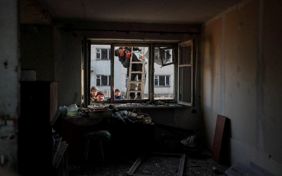 Locals survey the damage after shelling near Novoluhanske - REUTERS/Gleb Garanich