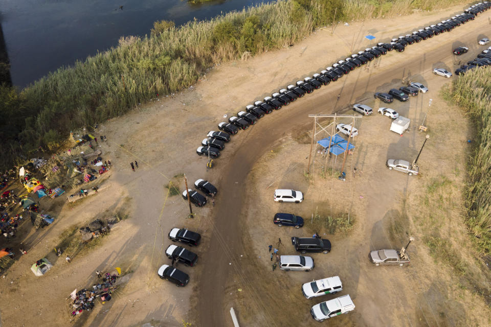 Texas Department of Safety vehicles line up along the bank of the Rio Grande near an encampment of migrants, many from Haiti, near the Del Rio International Bridge, Tuesday, Sept. 21, 2021, in Del Rio, Texas. The U.S. is flying Haitians camped in a Texas border town back to their homeland and blocking others from crossing the border from Mexico. (AP Photo/Julio Cortez)