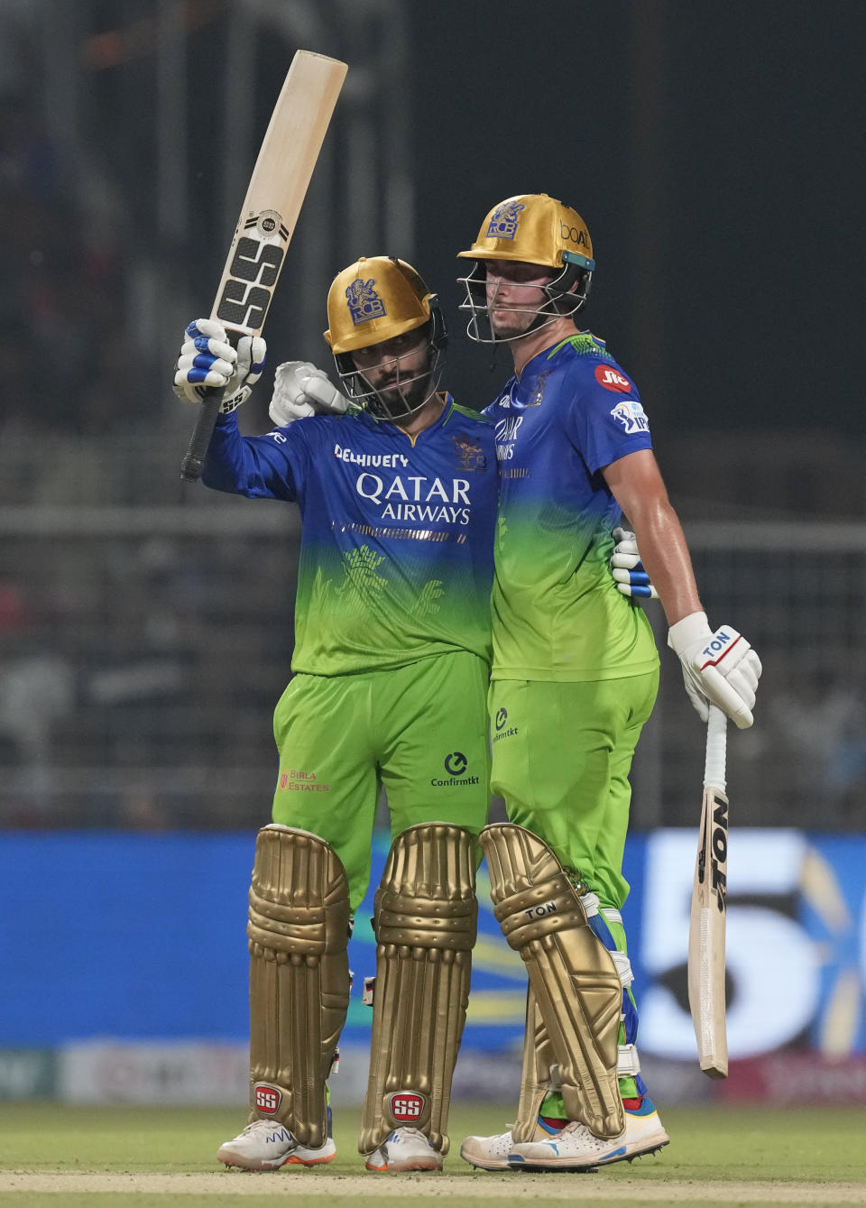 Royal Challengers Bengaluru's Rajat Patidar, left, is congratulated by teammate Will Jacks as he celebrates his fifty runs during the Indian Premier League cricket match between Kolkata Knight Riders and Royal Challengers Bengaluru in Kolkata, India, Sunday, April 21, 2024. (AP Photo/Bikas Das)