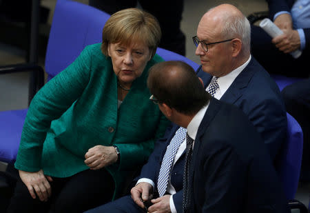 FILE PHOTO: German Chancellor Angela Merkel speaks to Volker Kauder, parliamentary group leader of the CDU/CSU faction, and Alexander Dobrindt, parliamentary group leader of the Christian Social Union (CSU), in the Bundestag in Berlin, Germany, June 28, 2018. REUTERS/Christian Mang/File Photo