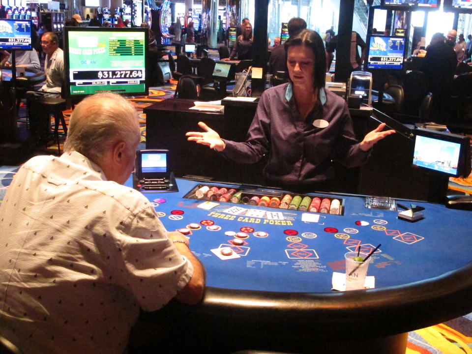 In this Sept. 28, 2018 photo, a dealer shows that her hands are empty during a card game at the Ocean Resort Casino in Atlantic City N.J. On Dec. 20, 2021, New Jersey lawmakers are scheduled to vote on an aid bill for Atlantic City's casinos that would scale back large increases in the amount they would have to pay the city and others in lieu of property taxes that would hit them next year if the bill is not enacted. (AP Photo/Wayne Parry)