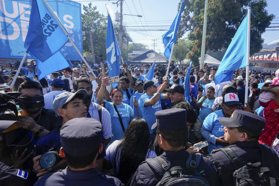 Supporters of El Salvador President Nayib Bukele, who is seeking re-election, gather outside the polling station where he voted during general elections in San Salvador, El Salvador, Sunday, Feb. 4, 2024. (AP Photo/Moises Castillo)