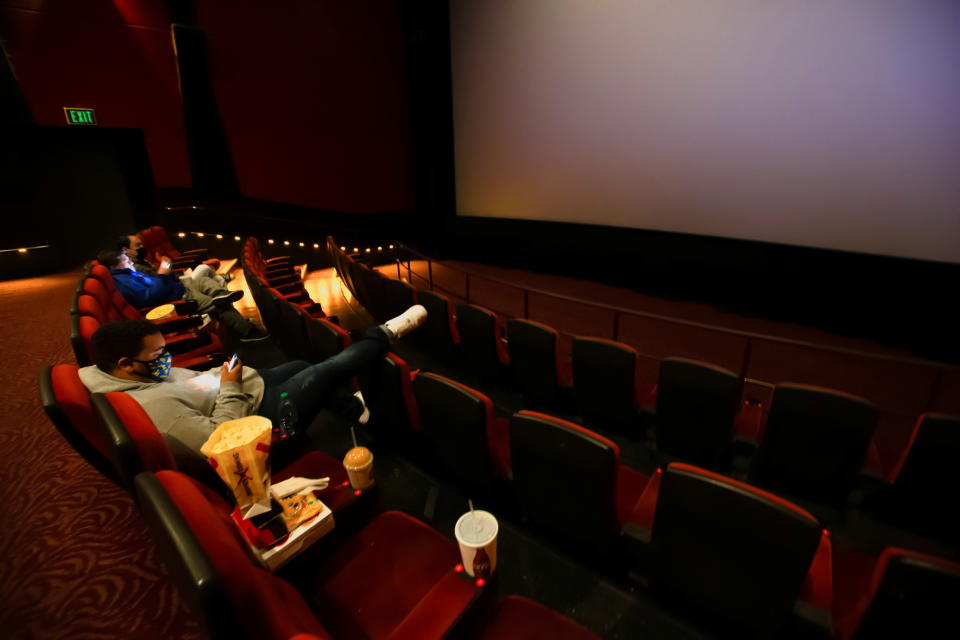 Patréin sëtzen an engem bal eidelen AMC Theater wärend se op den éischte Screening um Eröffnungsdag wärend dem Ausbroch vun der Coronavirus Krankheet (COVID-19), zu Burbank, Kalifornien, US, de 15. Mäerz 2021 waarden. REUTERS/Mario Anzuoni