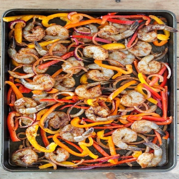 Uncooked shrimp fajitas on a baking sheet.