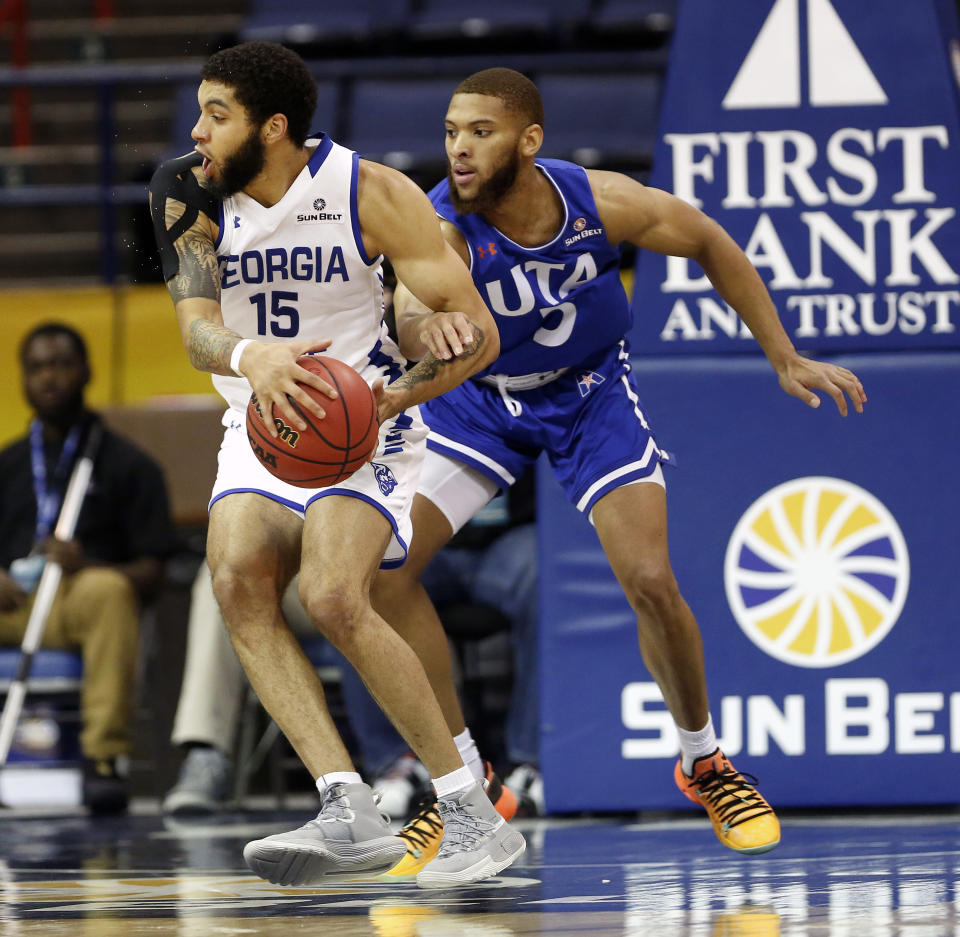Georgia State guard D'Marcus Simonds (23) is defended by Texas-Arlington guard Edric Dennis (5) during the first half of the NCAA college basketball championship game of the Sun Belt Conference men's tournament in in New Orleans, Sunday, March 17, 2019. (AP Photo/Tyler Kaufman)