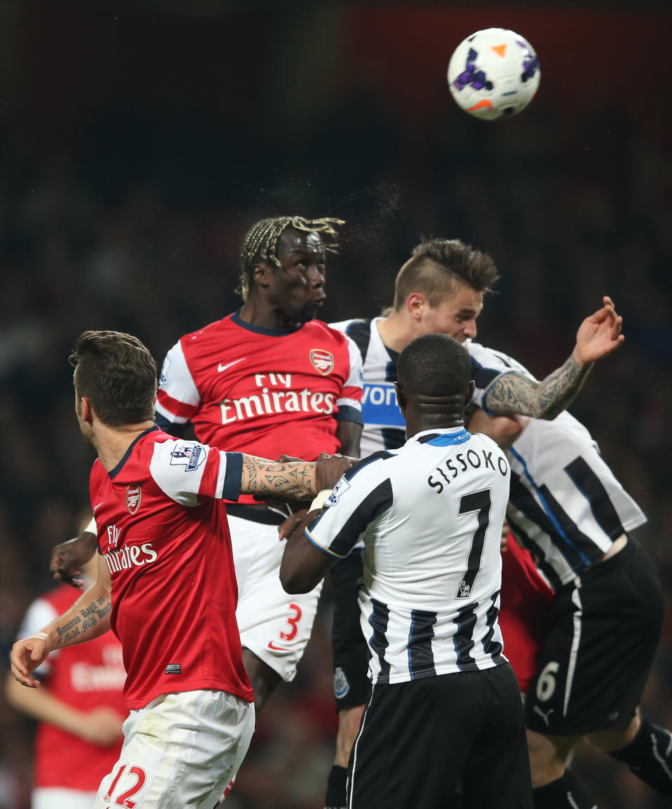 Arsenal's Bacary Sagna, top left heads the ball towards goal during their English Premier League soccer match between Arsenal and Newcastle United at the Emirates stadium in London, Monday, April 28, 2014. (AP Photo/Alastair Grant)
