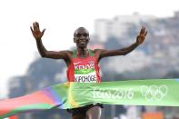 <p>Eliud Kipchoge of Kenya celebrates as he crosses the line to win gold during the Men’s Marathon on Day 16 of the Rio 2016 Olympic Games at Sambodromo on August 21, 2016 in Rio de Janeiro, Brazil. (Getty) </p>