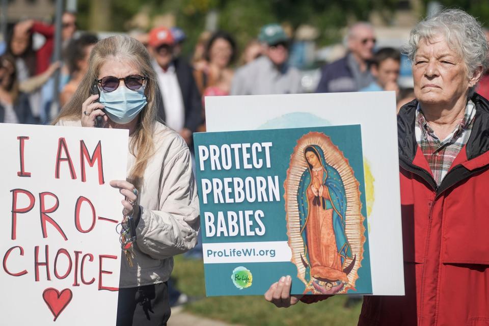 Kim Gasper-Rabuck, left, and Maria Gaboury, right, stand next to each other and express opposing views on abortion in front of Planned Parenthood's Madison East clinic. Ron Wyden (D-Ore.) said on Feb. 13, 2024 that an anti-abortion campaign targeted people visited 600 Planned Parenthood locations around the country.