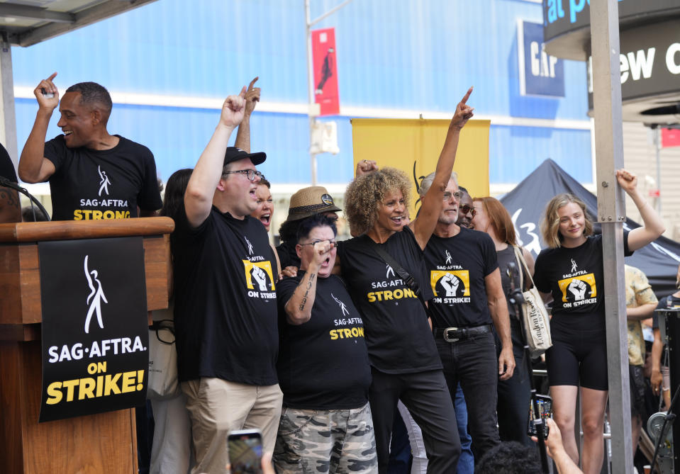 Hill Harper, from left, SAG-AFTRA national executive director and chief negotiator Duncan Crabtree-Ireland, Emma Myles, Lea DeLaria, Michelle Hurd, Stephen Lang, Lauren Ambrose, and Chloe Grace Moretz attend the SAG-AFTRA "Rock the City for a Fair Contract" rally in Times Square on Tuesday, July 25, 2023, in New York. The actors strike comes more than two months after screenwriters began striking in their bid to get better pay and working conditions. (Photo by Charles Sykes/Invision/AP)