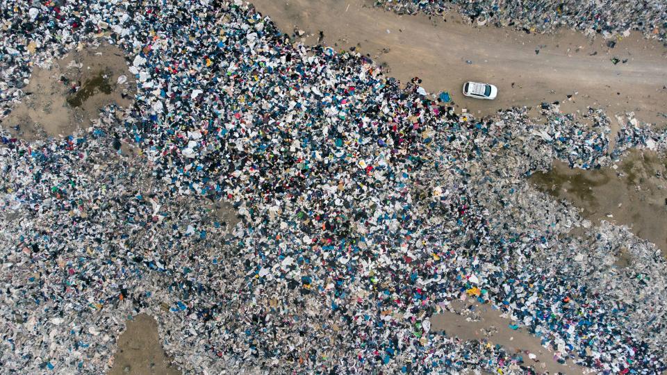 Aerial view of used clothes discarded in the Atacama desert, in Alto Hospicio, Iquique, Chile, on September 26, 2021.  EcoFibra, Ecocitex and Sembra are circular economy projects that have textile waste as their raw material. The textile industry in Chile will be included in the law of Extended Responsibility of the Producer (REP), forcing clothes and textiles importers take charge of the waste they generate.  / AFP / MARTIN BERNETTI