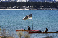 A Vegas Golden Knights flag flies from a kayak at Lake Tahoe offshore from the site of an outdoor NHL hockey game between the Golden Knights and the Colorado Avalanche at Stateline, Nev., Saturday, Feb. 20, 2021. (AP Photo/Rich Pedroncelli))