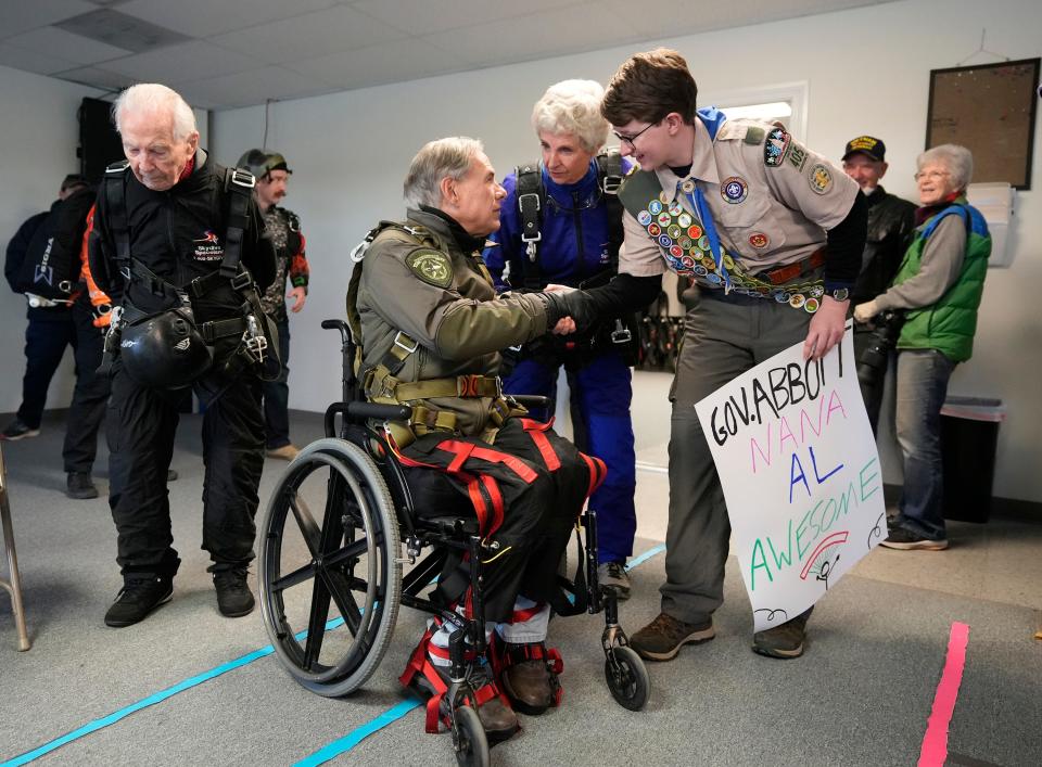 Gov. Greg Abbott greets Trevor Suggs, 15, before Abbott skydived with Suggs’ grandmother Betty Schleder, middle, and 106-year-old Al Blaschke at Skydive Spaceland in Fentress on Monday November 27, 2023.