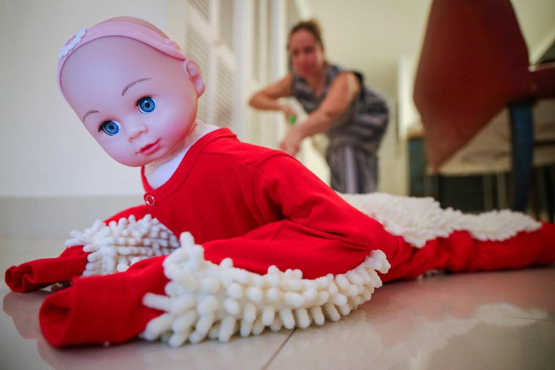 Anna Zilberberg cleans the floor with the Baby Mop Onesie, one of the gifts featured in the the Dave Barry 2022 Holiday Gift Guide.