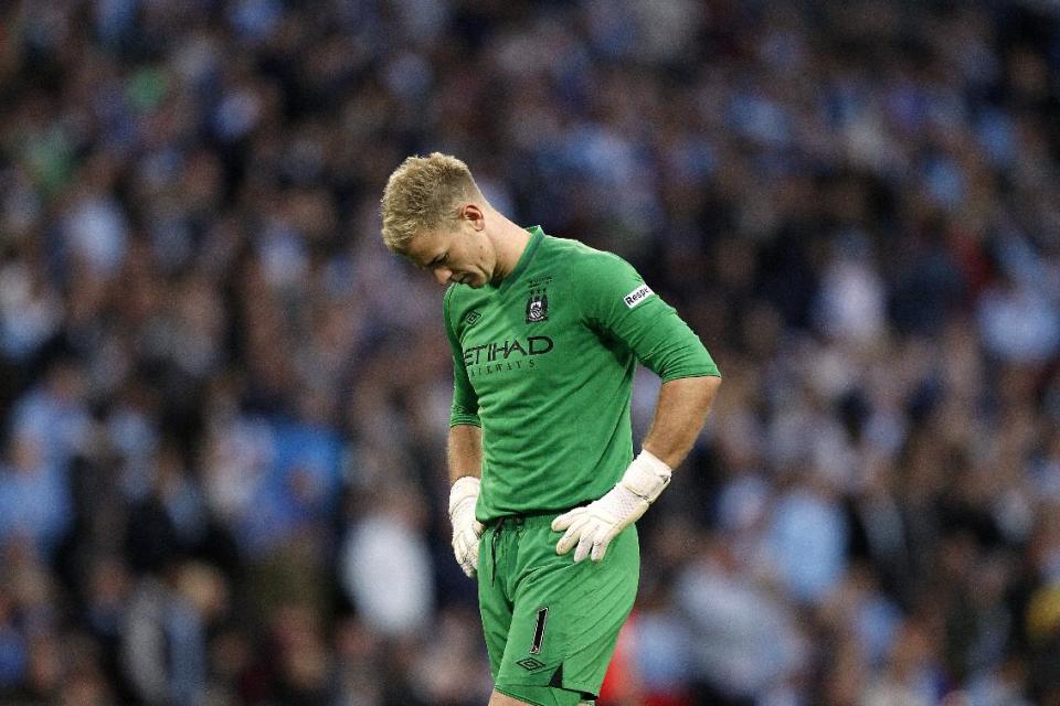 Manchester City goalkeeper Joe Hart stands dejected after conceding the winning goal, scored by Wigan Athletic's Ben Watson