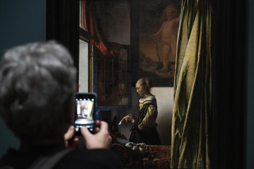 FILE - A woman takes images of Girl Reading a Letter at an Open Window, on loan from the Gemaelde Galerie Dresden, during a press preview of the Vermeer exhibit at Amsterdam's Rijksmuseum, Monday, Feb. 6, 2023. The blockbuster exhibition of paintings by Dutch Master Johannes Vermeer closed its doors for the final time Sunday, June 4, with the art and history national museum of the Netherlands hailing the show as its most successful ever. (AP Photo/Peter Dejong, file)