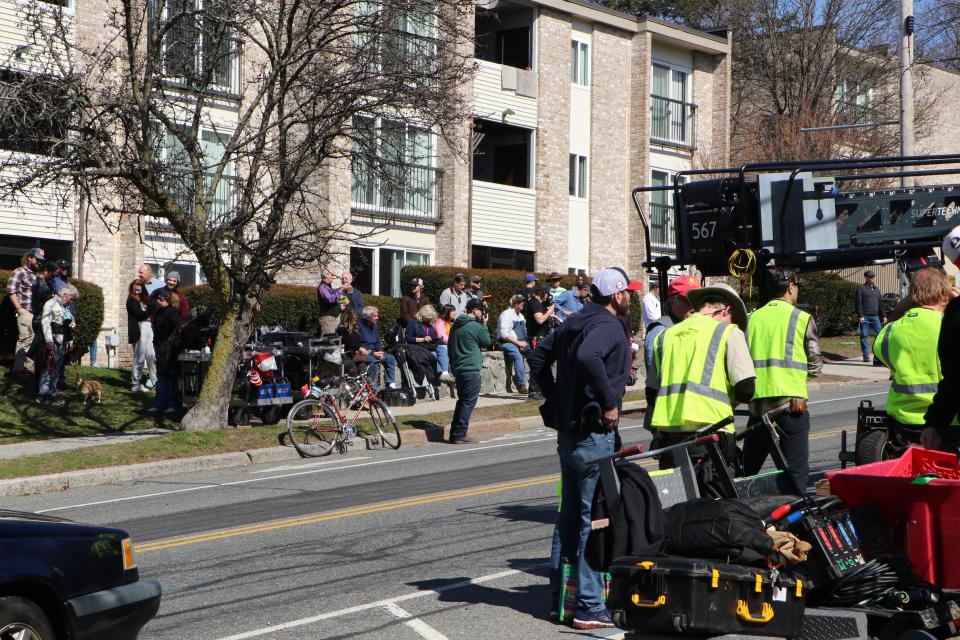 Spectators mingle with Twentieth Century Studios crew at the Thursday filming of "Ella McCay" outside University Heights Apartments at Pratt and Olney Streets.