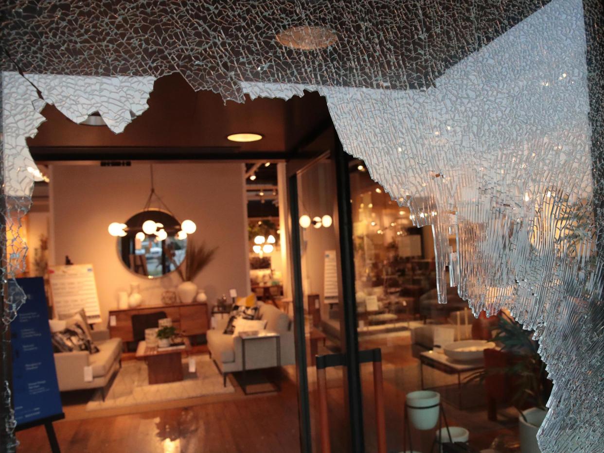 A broken storefront window is seen after parts of the city had widespread looting and vandalism, on 10 August 2020 in Chicago, Illinois. Police made several arrests during the night of unrest and recovered at least one firearm: (2020 Getty Images)