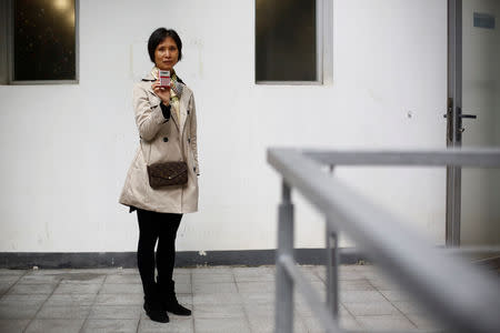 Former employee Lai Guixiang poses with a Sanyo pocket calculator she used to help make, in front of the Sanyo electronics factory where she worked since 1985, in the Shekou area of Shenzhen, Guangdong Province, China, December 14, 2018. "I feel like I have gone back twenty or thirty years ago, back to when we just started out here. Seeing all these exhibits. It has been 20 years since we saw each other. This time, at this 40th anniversary, everyone is here. Everyone is happy. We appreciate this opportunity. We were just girls then and now we are all grannies," she said about holding some of the old products and seeing former colleagues. Picture taken December 14, 2018. REUTERS/Thomas Peter