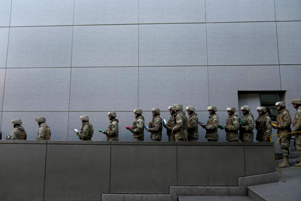 Soldiers retreat to the government palace after lowering the Bolivian national flag in Murillo square, in La Paz, Bolivia, Friday, June 28, 2024, two days after Army troops stormed the government palace in what Bolivia's President Luis Arce called a coup attempt. (AP Photo/Juan Karita)