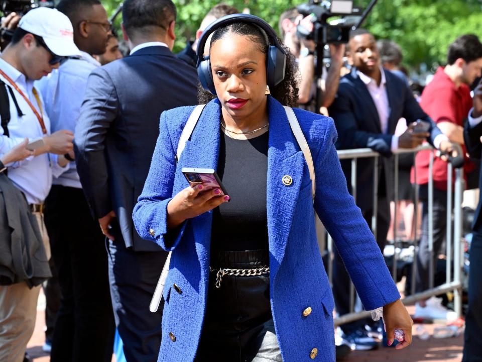 Rep. Summer Lee wears headphones as she departs House Democrats' meeting at the DNC on Tuesday.