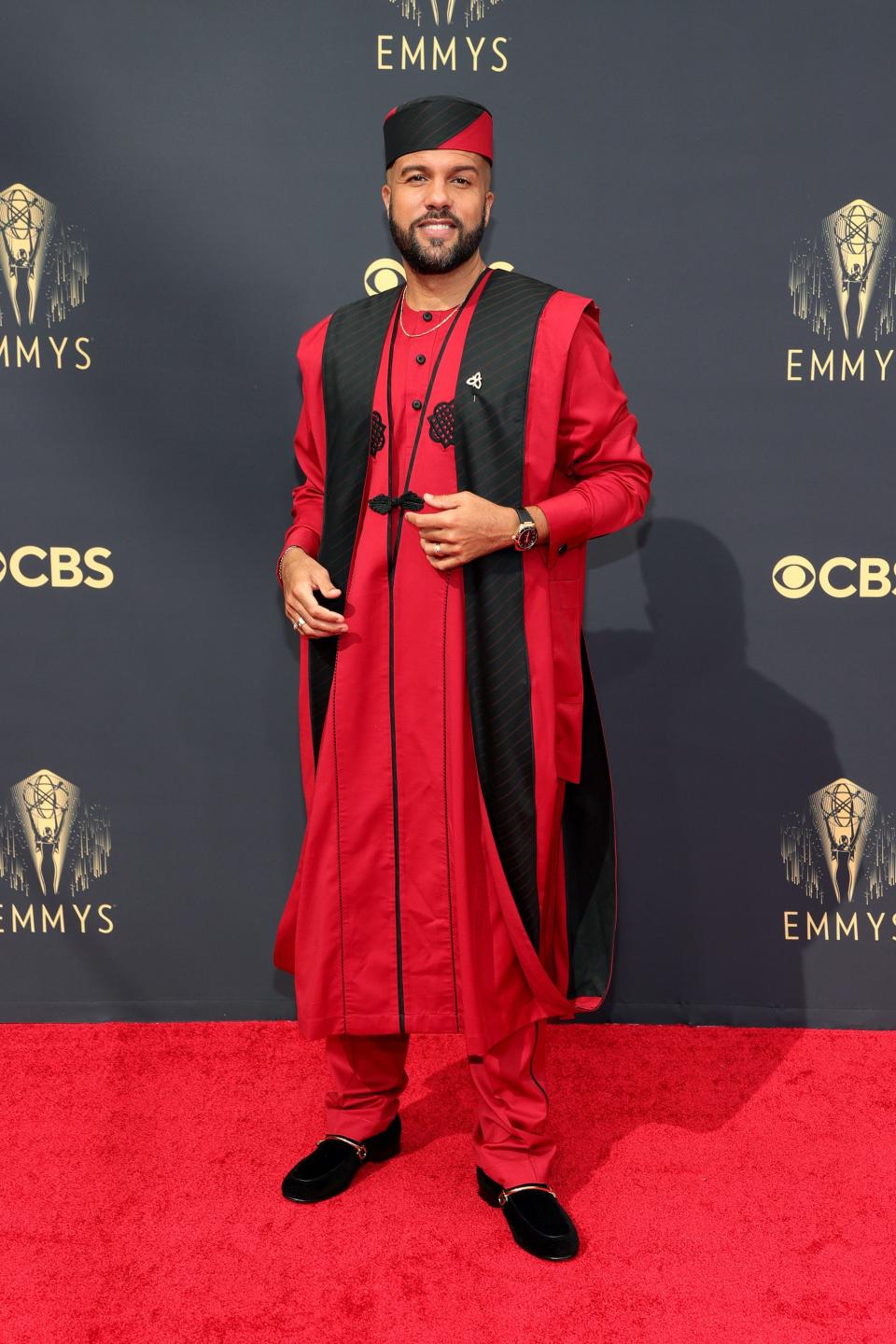 O-T Fagbenl wears a red and black outfit on the Emmys red carpet.