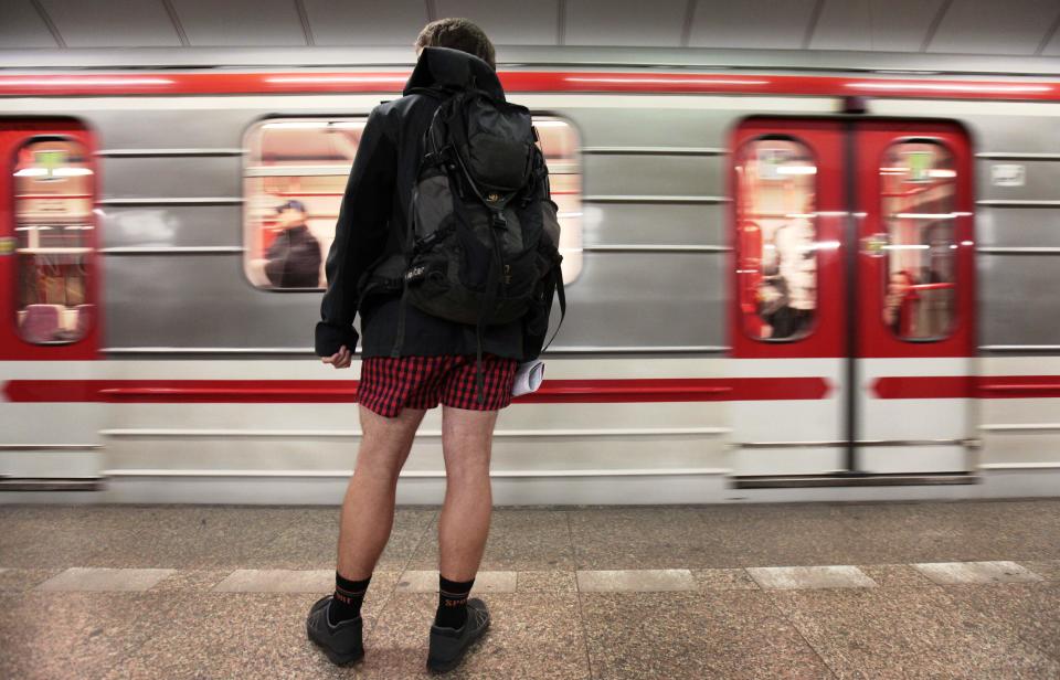 A passenger, not wearing pants, waits for a subway train during the "No Pants Subway Ride" in Prague