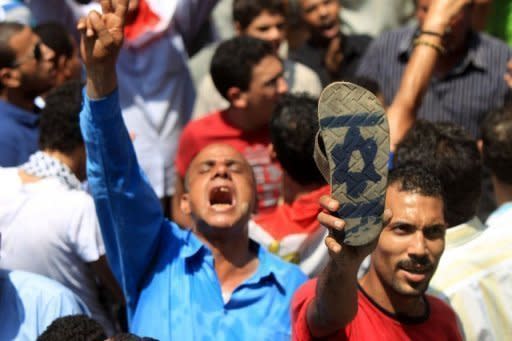 An Egyptian man shows the sole of his shoe painted with an Israeli flag during a protest outside the Israeli embassy in Cairo. Gaza's Popular Resistance Committees agreed to halt to rocket fire on Israel and abide by an Egyptian-brokered truce after four days of deadly clashes