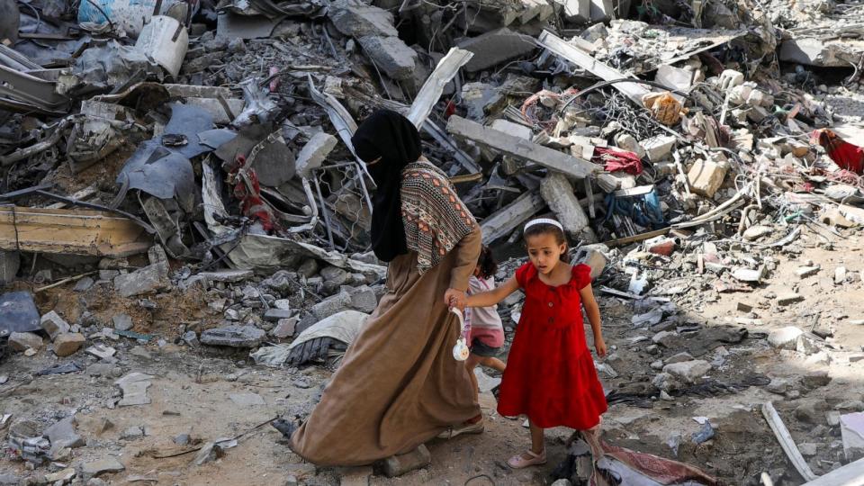 PHOTO: A woman and child walk among debris in aftermath of Israeli strikes at the area, where Israeli hostages were rescued on Saturday in Nuseirat refugee camp in the central Gaza Strip, June 9, 2024.  (Abed Khaled/Reuters)