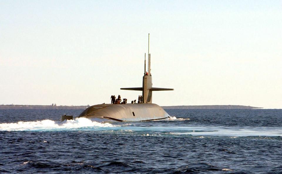 An Ohio-class Navy submarine surfaces out of the ocean off the coast of the Bahamas.