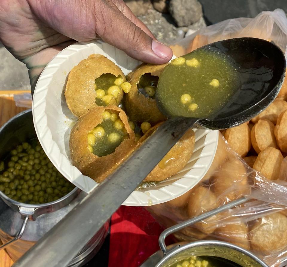 person adding filling to puri