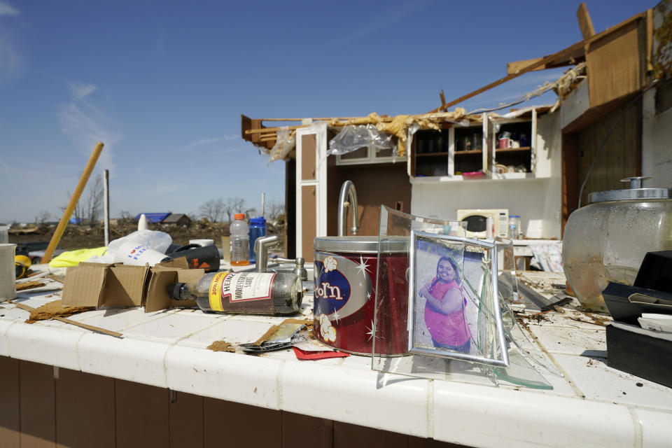A photo of a young softball player sits on the kitchen table of a Silver City, Miss., home, Tuesday, March 28, 2023. The home owners did not know who the person was in the photograph and believe it was one of the many displaced personal items from the Friday night killer tornado that hit a number of Mississippi communities, Tuesday, March 28, 2023. (AP Photo/Rogelio V. Solis)