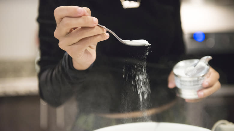 person adding baking soda