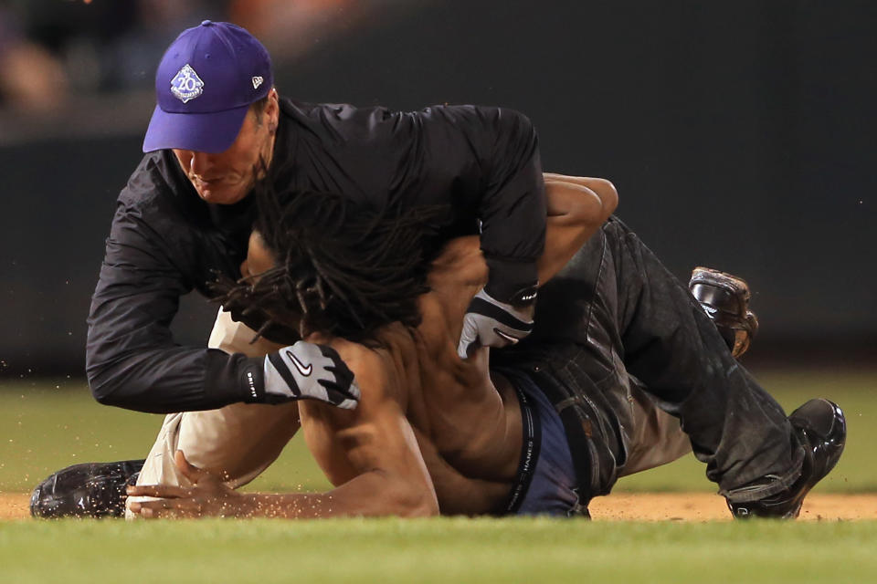 A fan that ran out on to the field is tackled by security as the Houston Astros face the Colorado Rockies at Coors Field on May 29, 2013 in Denver, Colorado. The Astros defeated the Rockies 6-3. (Photo by Doug Pensinger/Getty Images)