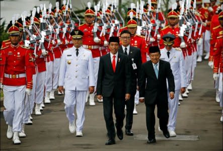 Presidential guards walk with (L-R) Jakarta Governor Anies Baswedan, Indonesia President Joko Widodo  and Vice President Jusuf Kalla for a swearing-in ceremony at the Presidential Palace in Jakarta, Indonesia, October 16, 2017. REUTERS/Beawiharta