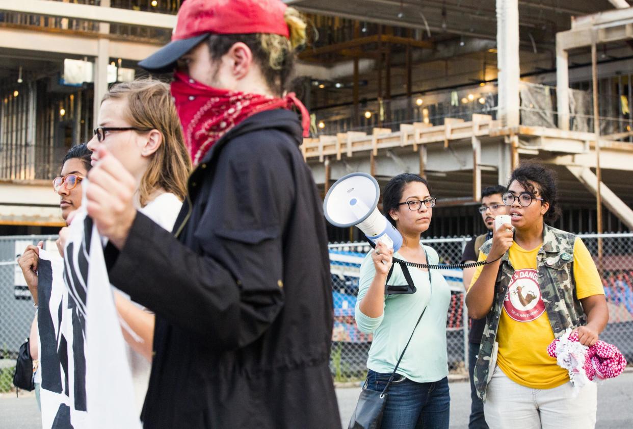 A group protests outside the new police headquarters in Durham before protestors tore down a Confederate monument: Casey Toth/The Herald-Sun via AP