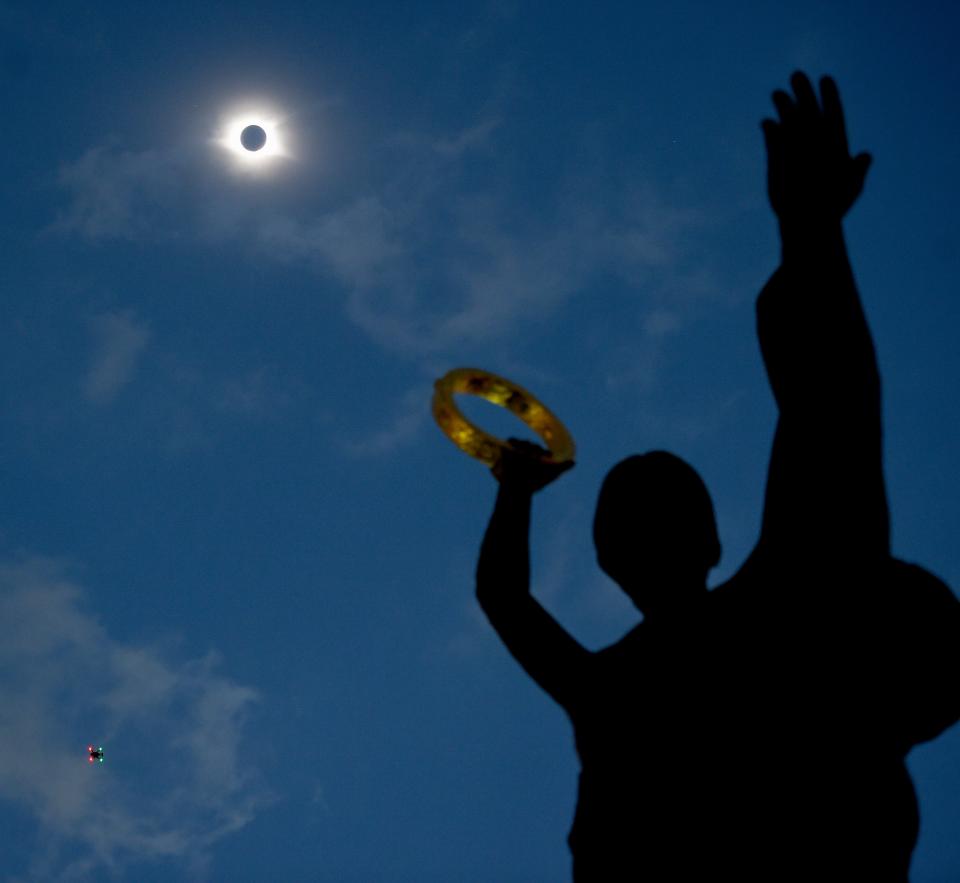 The sun goes into a total eclipse at the Musica statue on Music Row Monday, Aug. 21, 2017 in Nashville, Tenn.