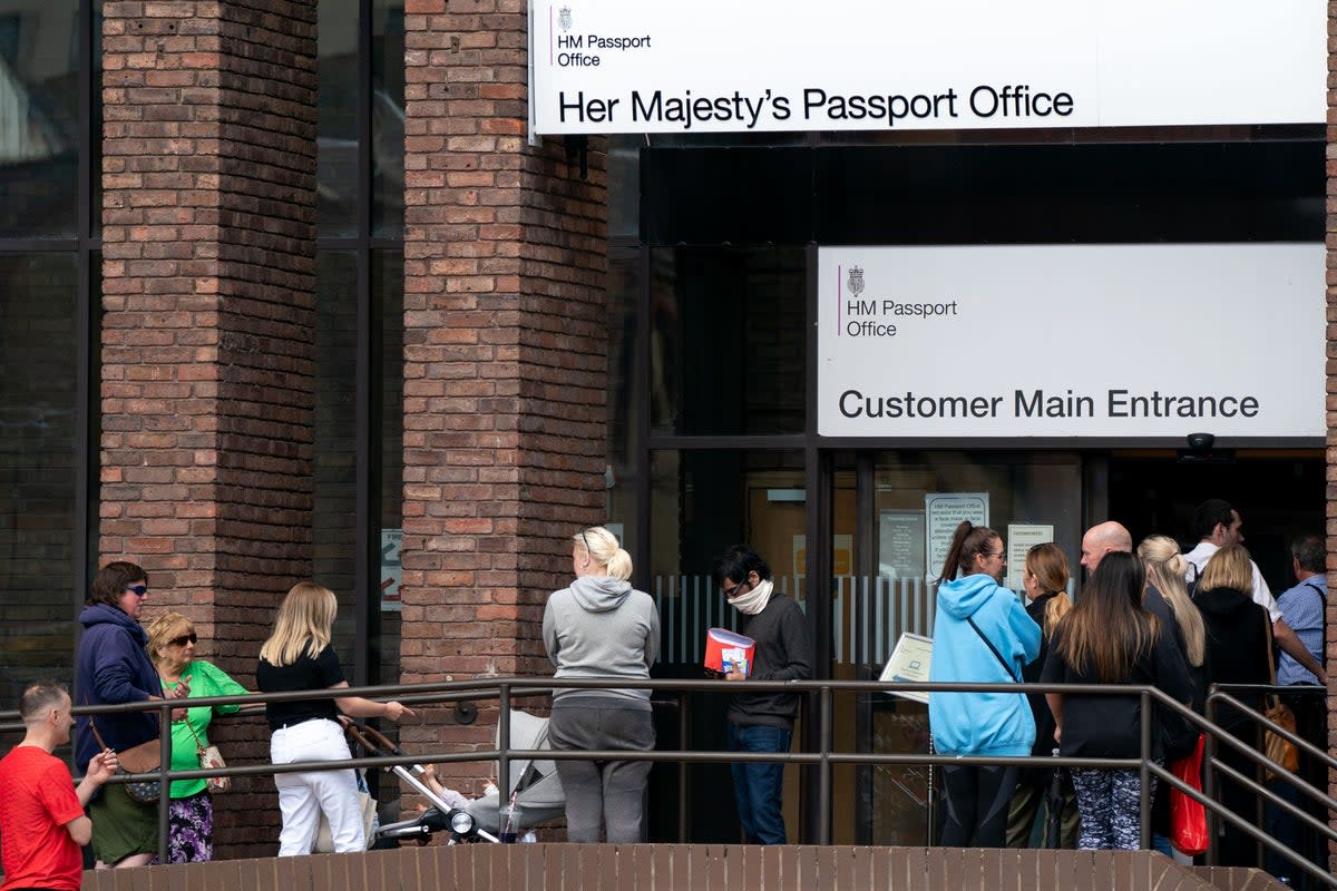 People queue outside the passport office in Peterborough (PA)