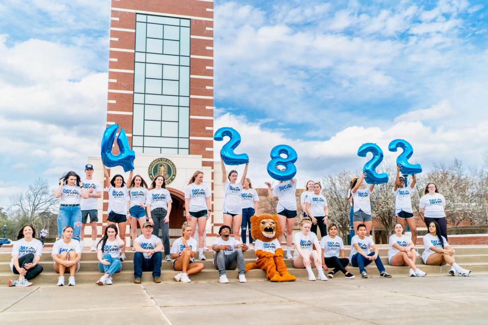 Ambassadors of UAFS student organizations hold up balloons signifying the date of the annual Day of Giving.