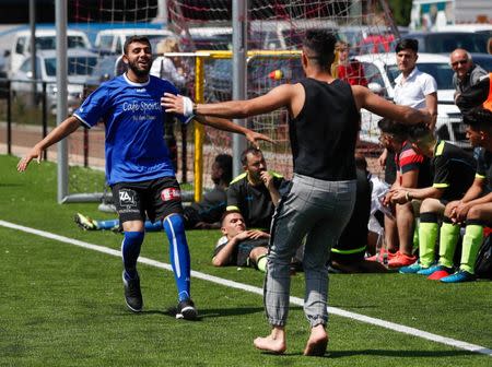 Asylum seekers celebrate while taking part in the soccer tournament "All on the pitch" organised by NGO's and Belgian Football Association at the occasion of the World Refugee Day, in Deurne, Belgium June 20, 2018. REUTERS/Yves Herman