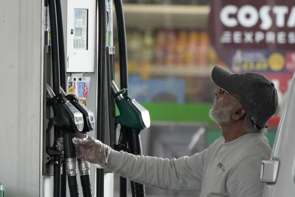 FILE - A driver looks at the petrol pump at a petrol station in London, Thursday, June 9, 2022. Britain’s new Prime Minister Liz Truss has pledged to rebuild the economy, but she faces a daunting job. Truss inherits an ailing economy on the brink of a potentially long recession, with record inflation and millions crying out for government help to cope with energy bills. (AP Photo/Frank Augstein, File)