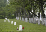 FiLE - In this Wednesday, May 23, 2018, file photo, white markers, each indicating a mass grave of about 150 people, are displayed on Hart Island in New York. On Monday, April 6, 2020, New York City Mayor Bill de Blasio said that officials are exploring the possibility of temporarily burying coronavirus victims on Hart Island, a one-mile, limited access strip off the Bronx borough of New York that has long served as the city's potter's field. The mayor told TV station NY1 that under such a contingency plan, bodies of COVID-19 victims would be buried individually, not in mass graves, so families could later reclaim them. (AP Photo/Seth Wenig, File)