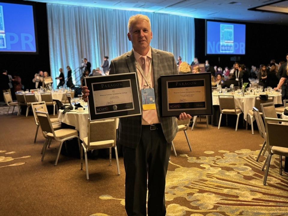 Joe Verkennes, MCCC director of marketing and communications, poses with the college's national Paragon Awards from the National Council for Marketing and Public Relations.
